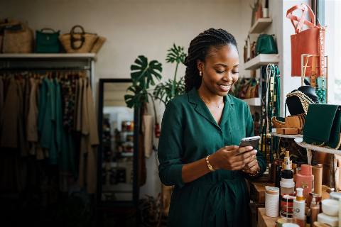 Commerçante gérant sa boutique depuis son téléphone